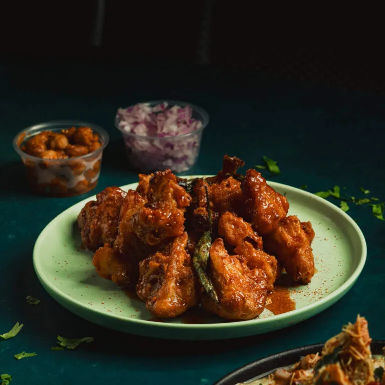 Chicken tikka bites on a green plate